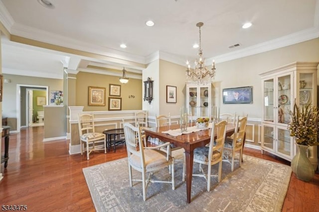 dining room with visible vents, recessed lighting, crown molding, and wood finished floors