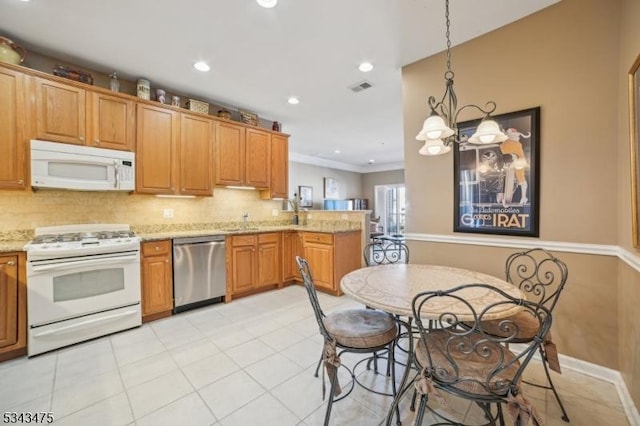 kitchen with visible vents, light stone counters, tasteful backsplash, white appliances, and a peninsula