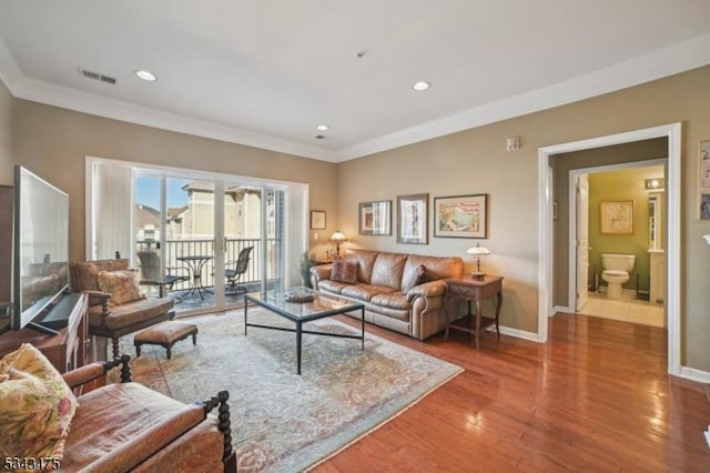 living area with visible vents, crown molding, baseboards, recessed lighting, and wood finished floors