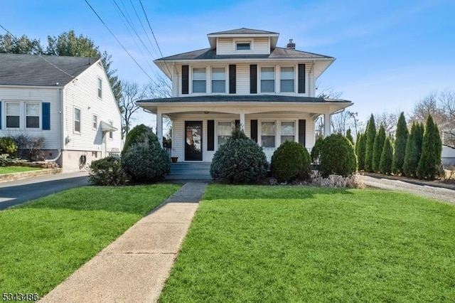 traditional style home with covered porch and a front yard