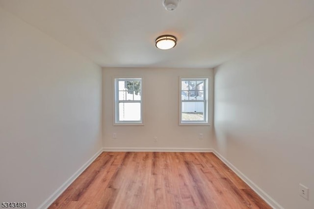 empty room with baseboards and light wood finished floors