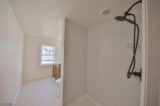 full bathroom featuring tile patterned floors, toilet, baseboards, and a tile shower