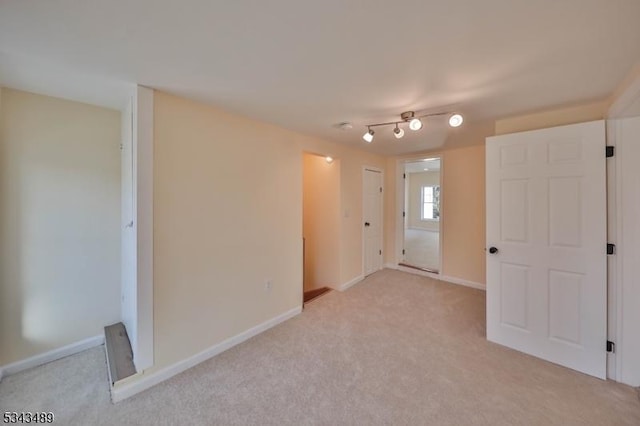 empty room with baseboards and light colored carpet