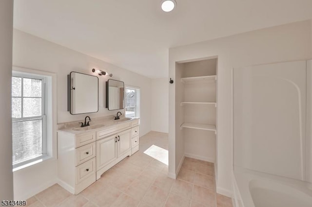 bathroom featuring double vanity, plenty of natural light, and a sink