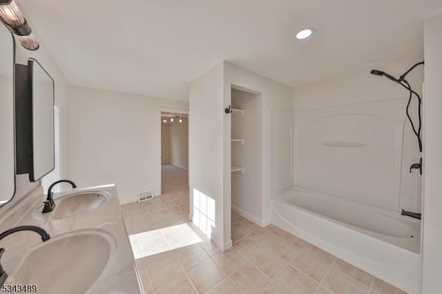 bathroom featuring tile patterned floors, visible vents, shower / bathtub combination, and a sink