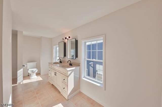 bathroom featuring tile patterned floors, double vanity, toilet, and a sink