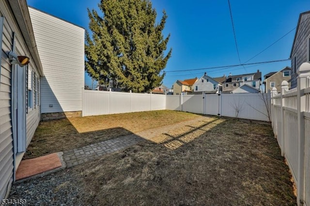 view of yard featuring a fenced backyard and a residential view