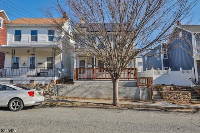 view of property featuring a porch and fence