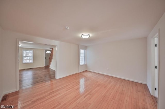 unfurnished room featuring visible vents, light wood-style flooring, and baseboards