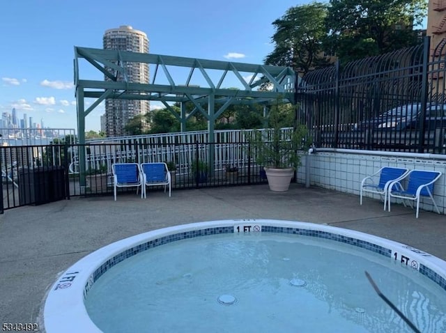 view of pool with fence, a city view, and a patio
