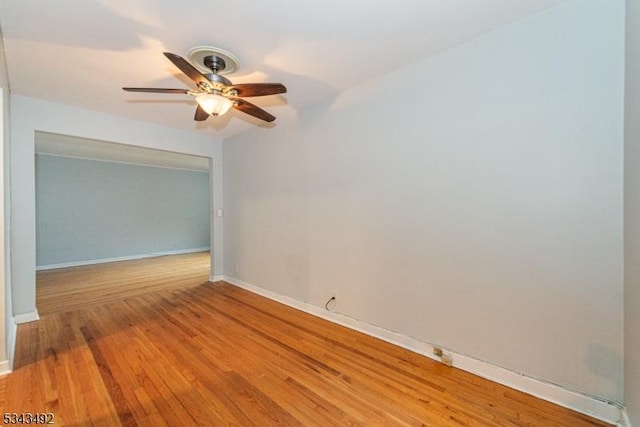 spare room with a ceiling fan, baseboards, and wood finished floors