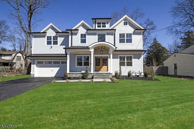 view of front of home featuring a standing seam roof, an attached garage, a front lawn, aphalt driveway, and metal roof