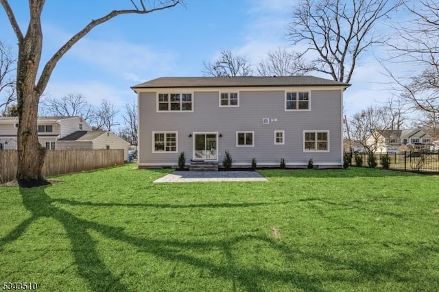 back of property featuring a lawn and fence