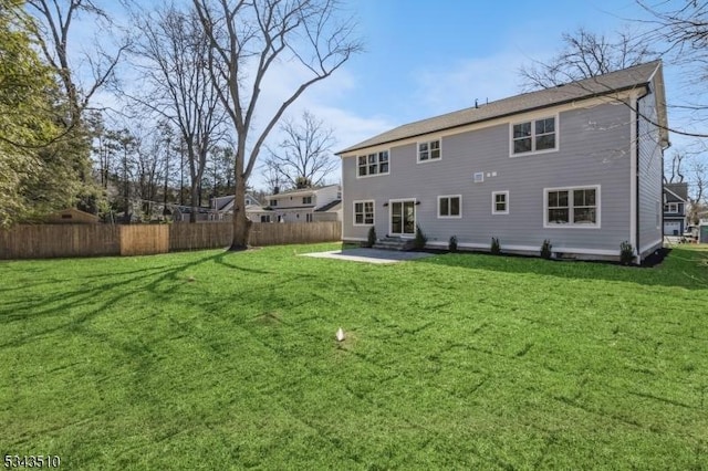 back of house featuring entry steps, a patio area, a yard, and fence