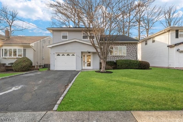 split level home featuring a front lawn, stone siding, and driveway