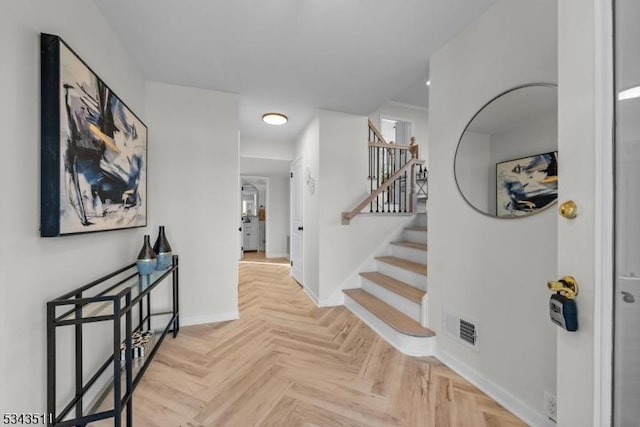 entrance foyer with visible vents, stairway, and baseboards