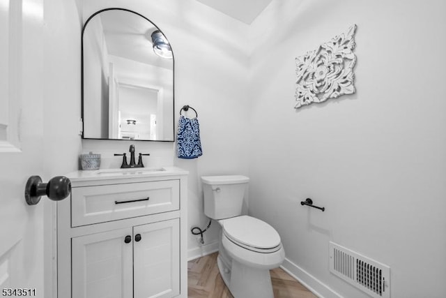 bathroom with visible vents, baseboards, toilet, and vanity