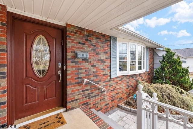 doorway to property with brick siding