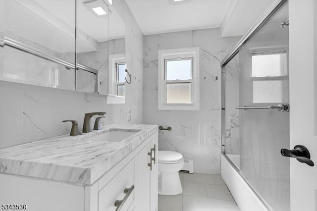 bathroom with toilet, a baseboard heating unit, vanity, tile walls, and shower / bathtub combination