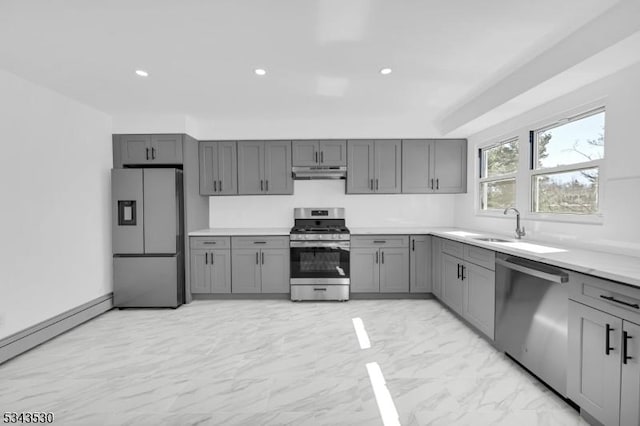 kitchen featuring gray cabinetry, stainless steel appliances, light countertops, under cabinet range hood, and marble finish floor