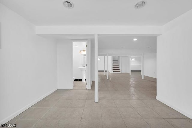 spare room featuring stairway, baseboards, light tile patterned flooring, recessed lighting, and a sink