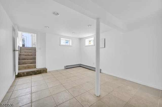 basement with tile patterned floors, baseboards, baseboard heating, and stairs