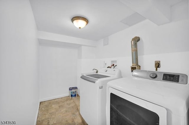 clothes washing area featuring washing machine and clothes dryer and laundry area