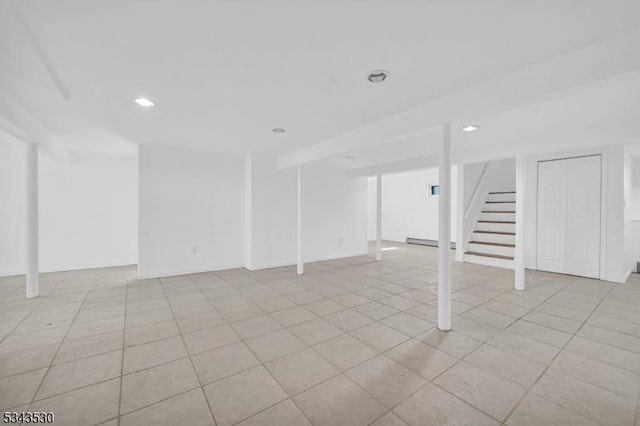 finished basement with recessed lighting, stairway, and light tile patterned floors