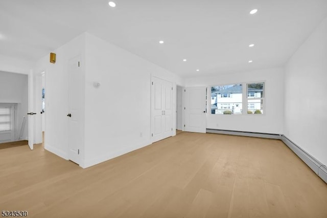 spare room with recessed lighting, light wood-style floors, and baseboard heating