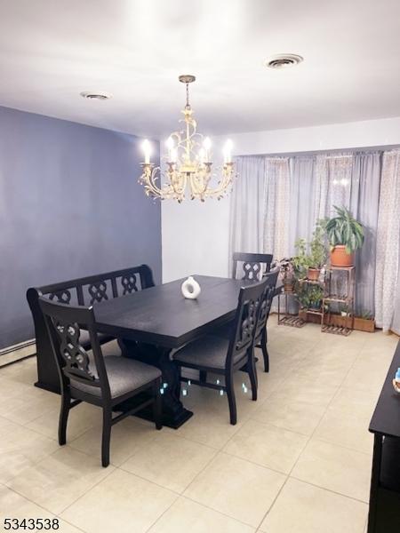 dining space featuring a chandelier and visible vents