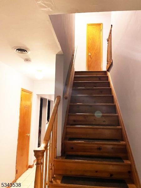 stairway featuring visible vents and baseboards