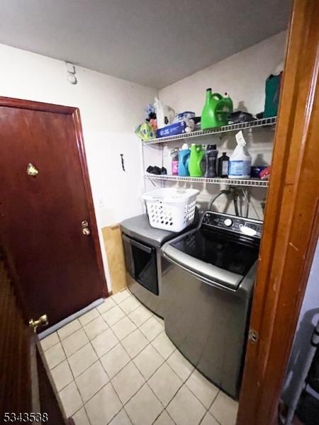 clothes washing area with light tile patterned floors, laundry area, and independent washer and dryer