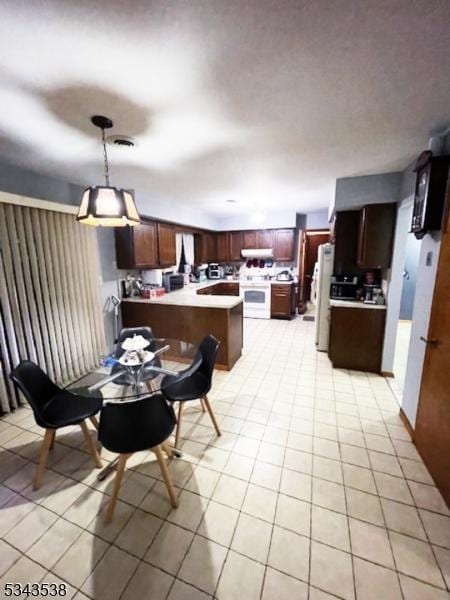 kitchen with white appliances, light countertops, a peninsula, and under cabinet range hood