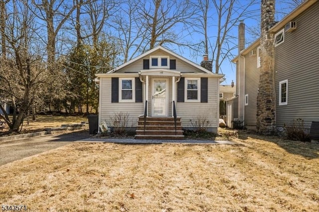 bungalow-style home featuring entry steps and a chimney