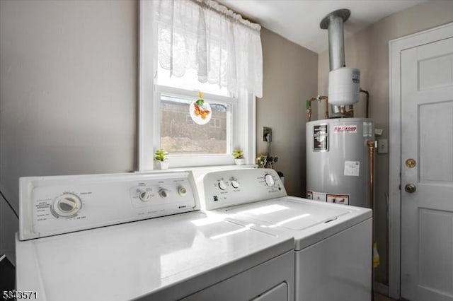 clothes washing area featuring washer and dryer, laundry area, and water heater