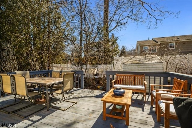 wooden terrace with outdoor dining area and fence