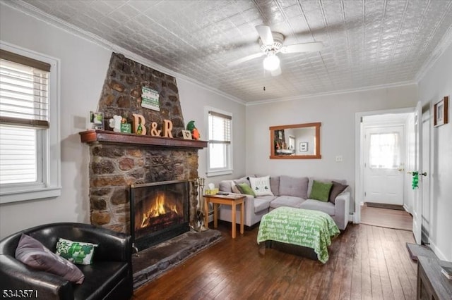 living room with a fireplace, crown molding, hardwood / wood-style flooring, and a healthy amount of sunlight