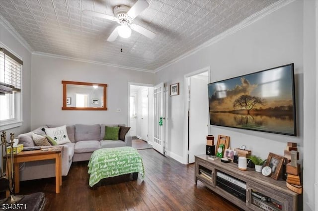 living area with baseboards, ceiling fan, ornamental molding, wood finished floors, and an ornate ceiling