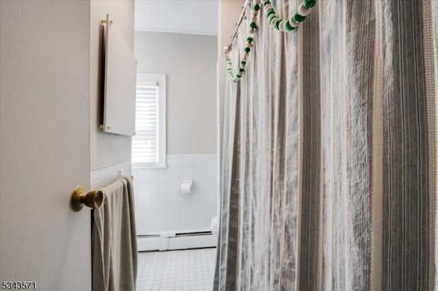 full bathroom featuring a wainscoted wall, tile walls, a baseboard heating unit, and a shower with curtain