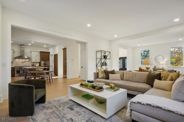 living area with recessed lighting, light wood-type flooring, and baseboards