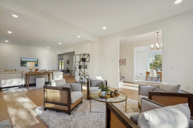 living room featuring recessed lighting, a notable chandelier, and light wood finished floors