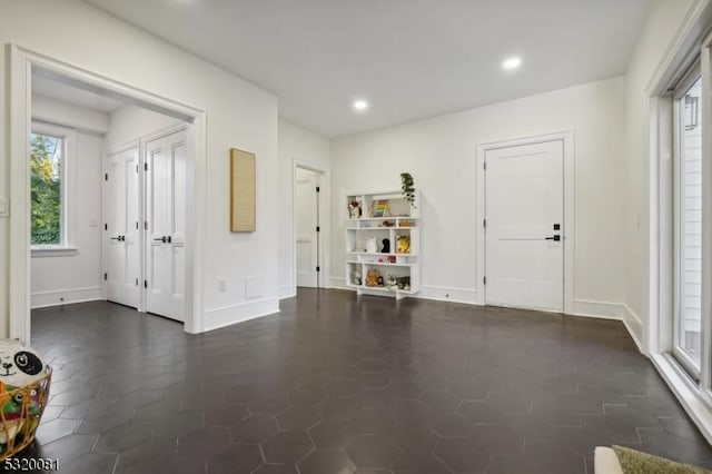 entrance foyer with recessed lighting, baseboards, and dark tile patterned flooring