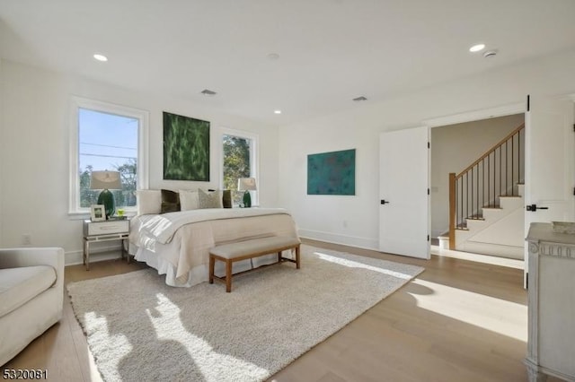 bedroom with recessed lighting, wood finished floors, and baseboards