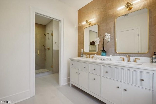 full bathroom with double vanity, a shower stall, tile walls, and a sink