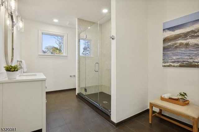 bathroom featuring recessed lighting, baseboards, a stall shower, and vanity