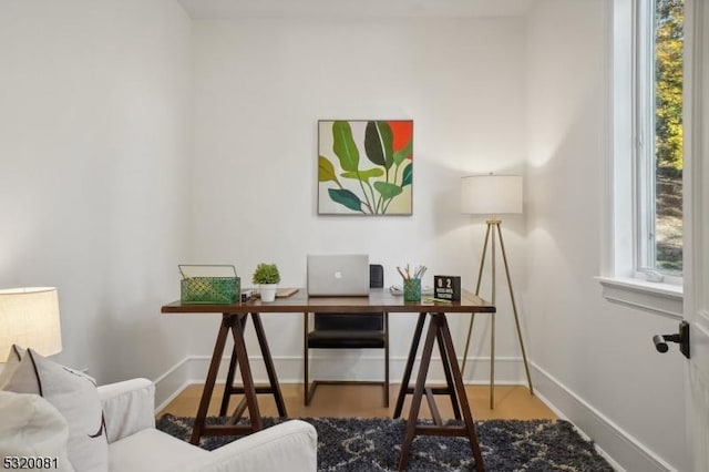 home office with wood finished floors, baseboards, and a wealth of natural light