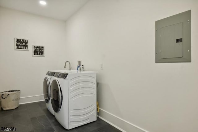 laundry area with electric panel, laundry area, washing machine and dryer, and baseboards