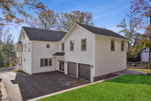 back of property featuring driveway, fence, a yard, a garage, and a patio area