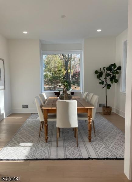 dining room with wood finished floors, recessed lighting, visible vents, and baseboards