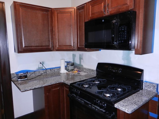 kitchen featuring black appliances and light stone countertops